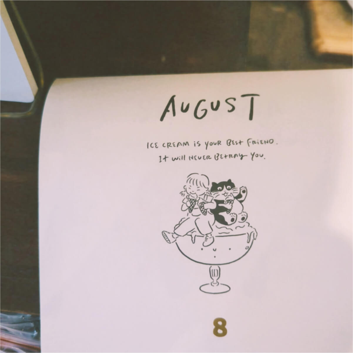 Close up view of an August calendar that says - "Ice cream is your best friend. It will never betray you."