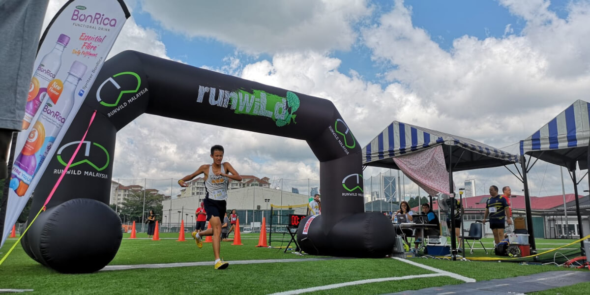 Guo running past the finish line, very exhausted.