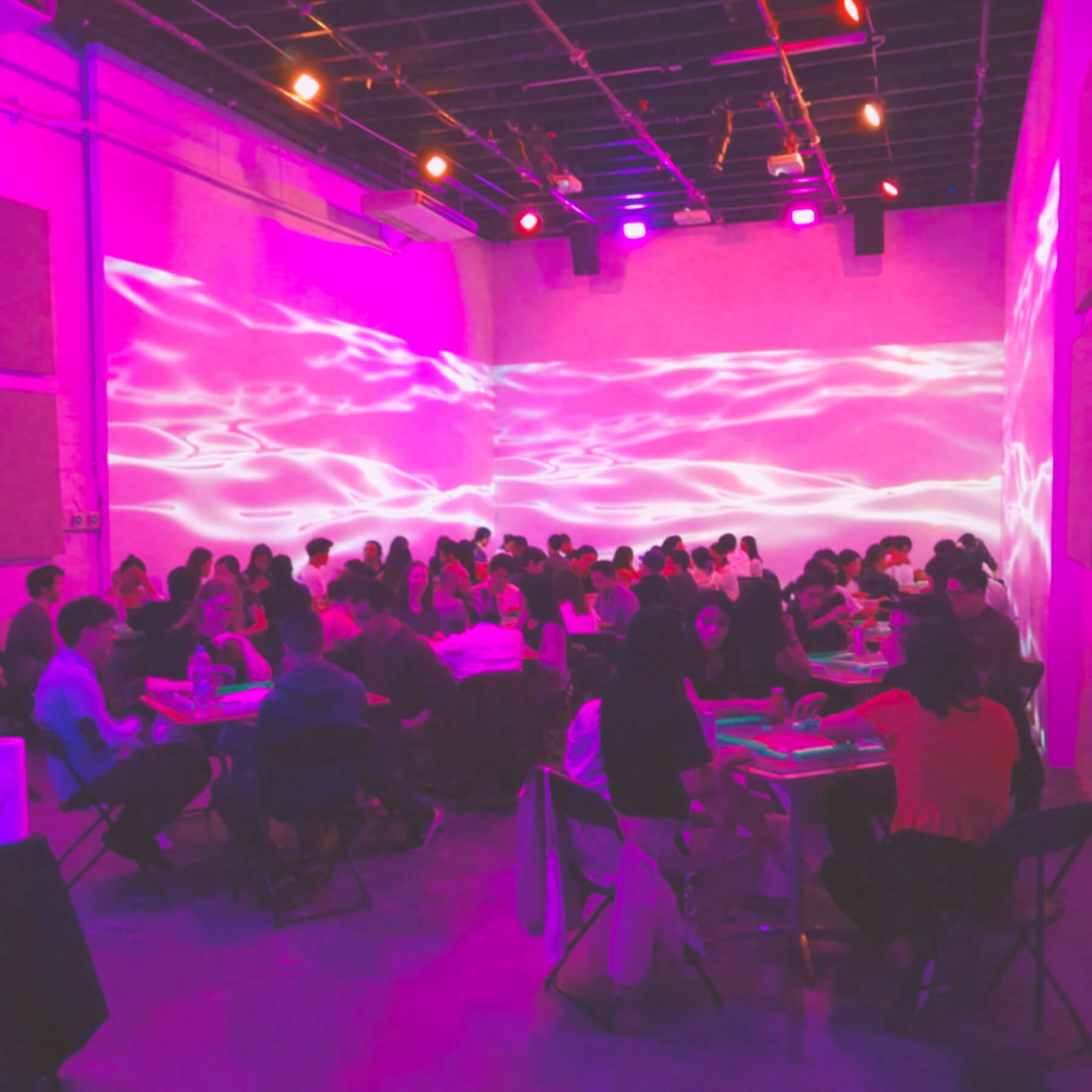 Lots of people playing mahjong with a wavy backdrop